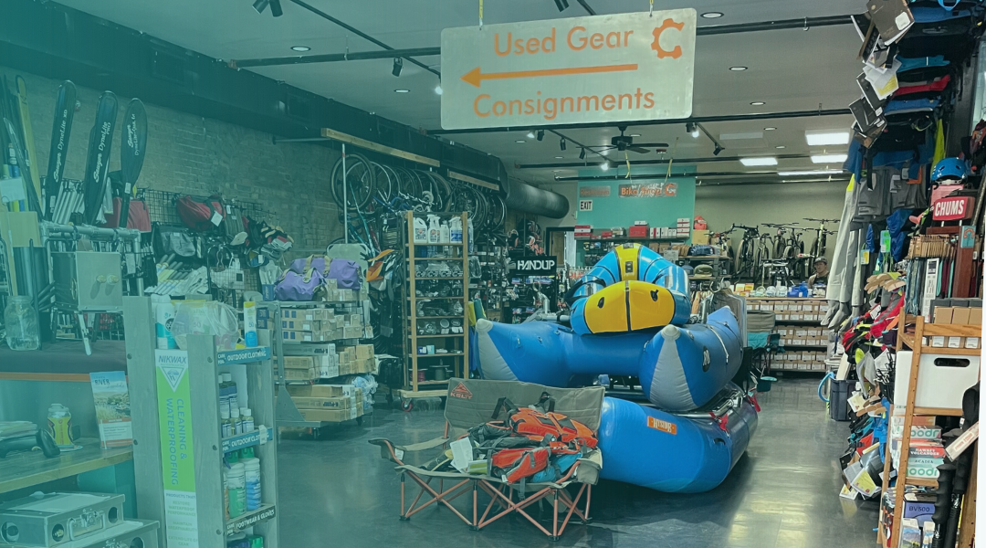 Inside the Gear Junction shop with river rafts, bikes, paddling gear, and a used gear consignments sign.