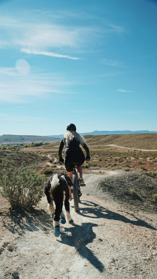 A woman and her dog enjoy 18 road mountain bike trails near Fruita, CO