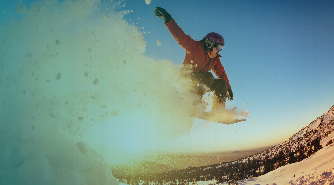 Person snowboarding on Grand Mesa with a clear blue sky